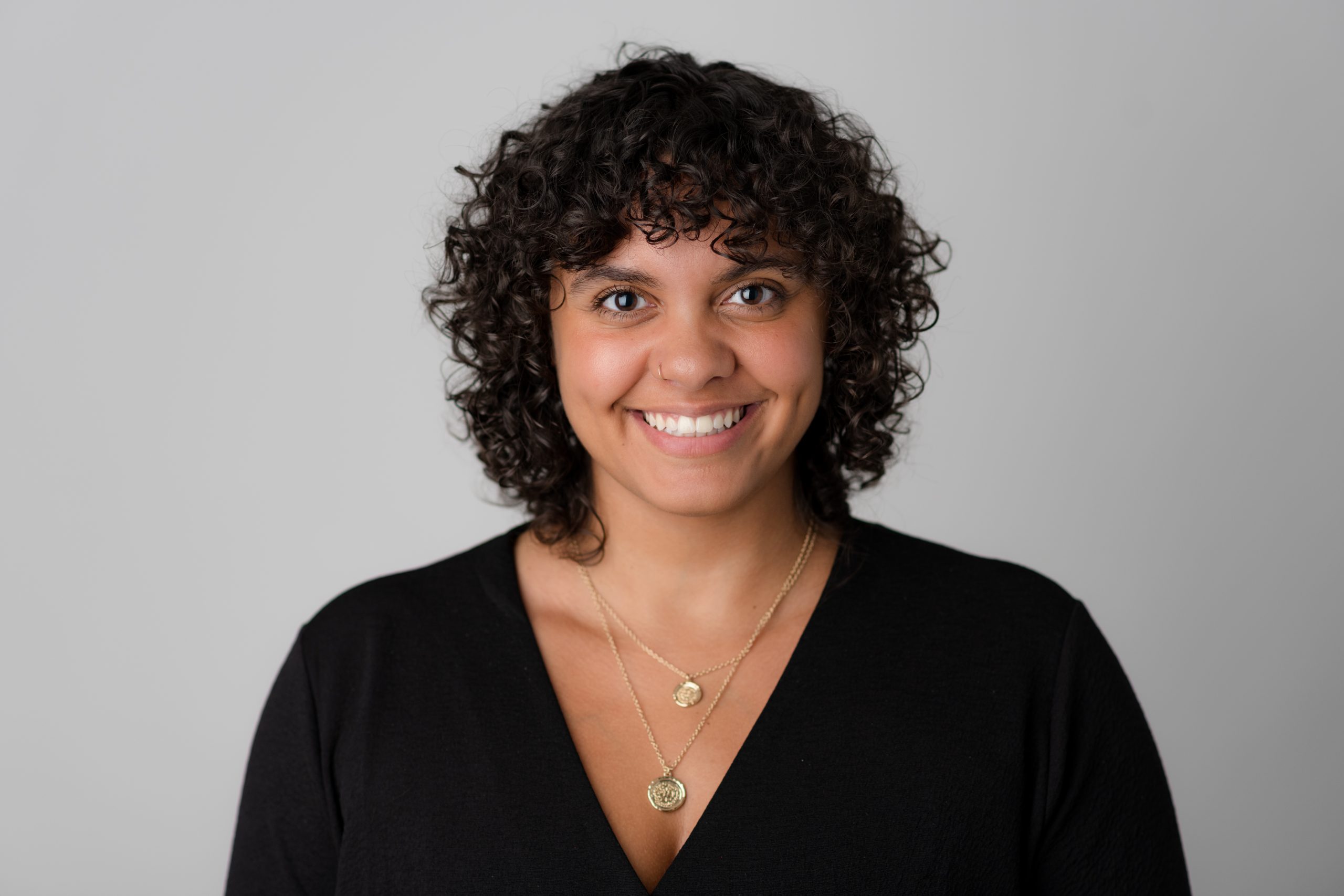 Image of strategic health communications consultant, Bria, a Black woman in her early thirties with shoulder-length curly hair.